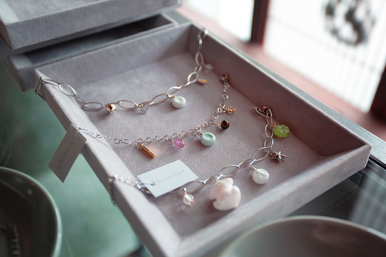 ギフトボックスに収められた天然石とパールのブレスレット。シルバーチェーンにカラフルな石があしらわれている